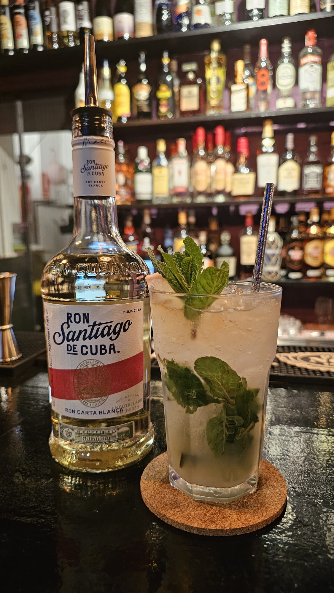Mojito y botella de ron Santiago de Cuba en la barra de Gaby's Club