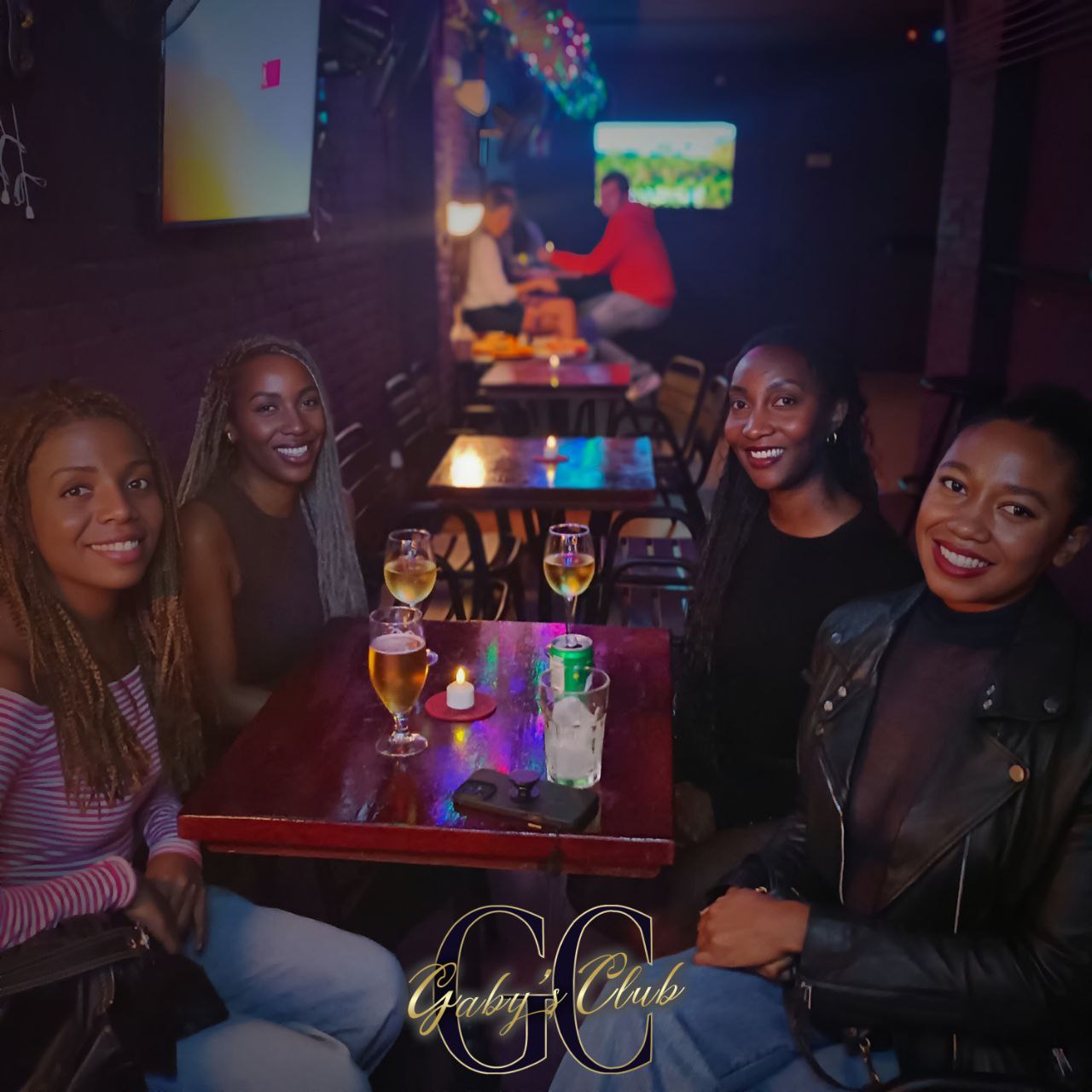 Grupo de amigas con cócteles en una mesa de Gaby's Club